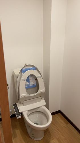 a bathroom with a toilet with the seat up at 大阪長居港湾客房 in Osaka