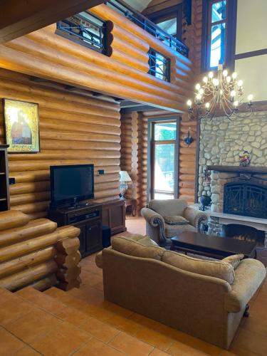 un soggiorno con divano e TV in una cabina di Relaxation in Guta Гута a Guta