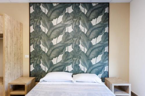 a bedroom with a large wall mural of leaves at Affittacamere Flavia Roma in Ostia Antica