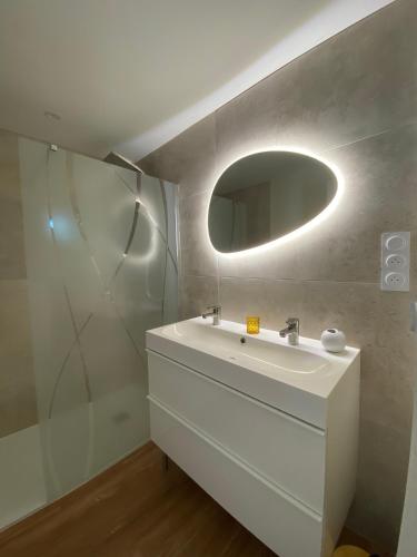 a bathroom with a white sink and a mirror at La Maison de Jeanne in Narbonne