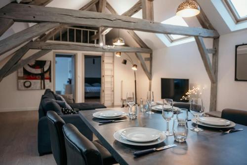 une salle à manger avec une longue table et des chaises dans l'établissement Appartement de Romain, à Charleville-Mézières