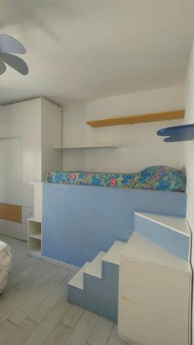 a room with a blue bed and stairs in it at Isola del Giglio casa Nico e casa Camilla Monticello Giglio Porto in Isola del Giglio