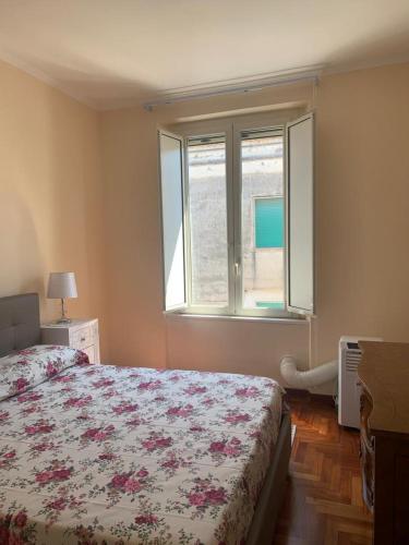 a bedroom with a bed and a large window at Sotto le stelle di Capua in Capua