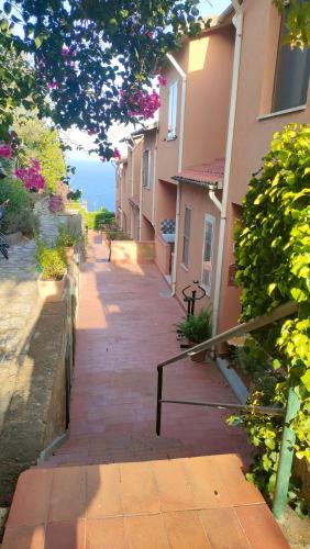 a walkway between two buildings with a view of the ocean at Isola del Giglio casa Nico e casa Camilla Monticello Giglio Porto in Isola del Giglio
