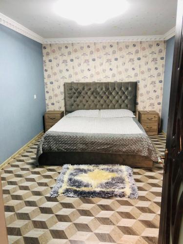 - une chambre avec un grand lit et un tapis dans l'établissement RADENO HOUSE, à Tbilissi