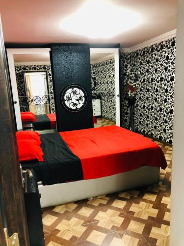 - une chambre dotée d'un grand lit avec des draps rouges et noirs dans l'établissement RADENO HOUSE, à Tbilissi
