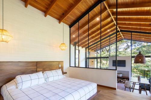 a bedroom with a large bed and a large window at Casas Jaguar in Monteverde Costa Rica