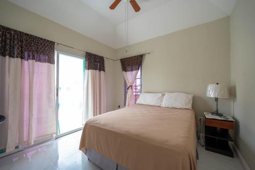 um quarto com uma cama e uma grande janela em JAG Guesthouse- Little Bay Country Club em Negril