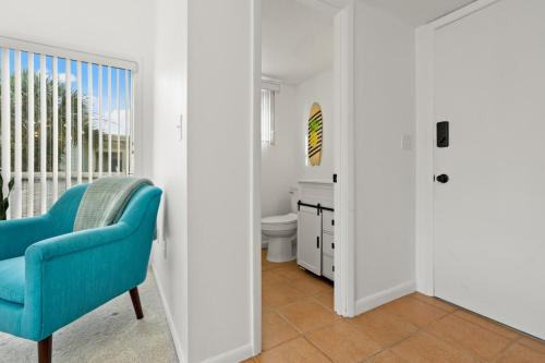 a room with a blue chair and a bathroom at Beach Break Ocean Front Complex Beach Pool in Saint Augustine