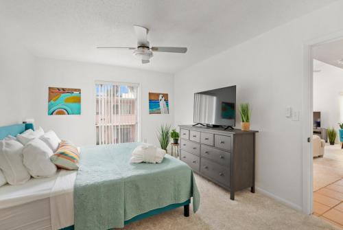 a bedroom with a bed and a dresser and a tv at Beach Break Ocean Front Complex Beach Pool in Saint Augustine