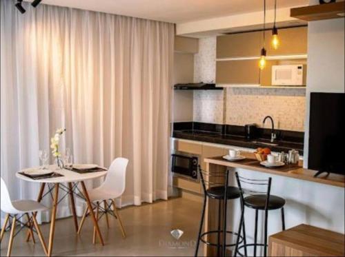 a kitchen with a table and chairs in a kitchen at Flat lindo com piscina e linda vista da cidade in São Lourenço