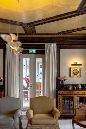 a living room with a couch and a chair and a door at Valverde Santar Hotel & SPA - Relais & Châteaux in Santar
