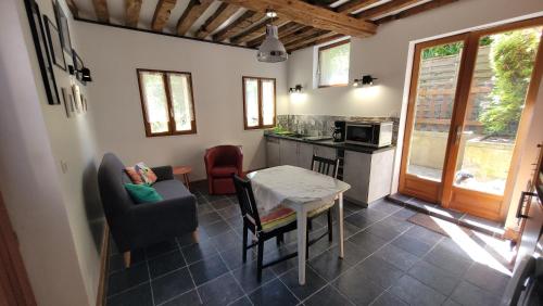 a kitchen and living room with a table and chairs at Le Jardin des Murmures in Honfleur