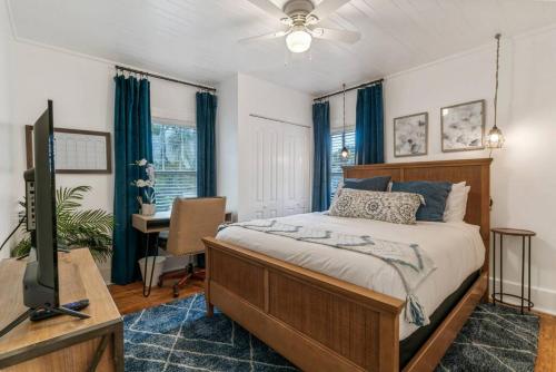 聖奧古斯丁的住宿－Blue Haven Beach Hot Tub History，一间卧室配有一张床、一台电视和一张书桌