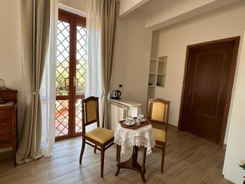 een eetkamer met een tafel en stoelen en een raam bij Il Sogno delle Rondini in Palidoro