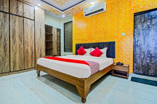 a bedroom with a bed and a yellow wall at Collection O Collection O Hotel My Stay Retreat in Jaipur
