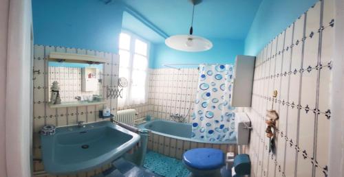 ein blaues Bad mit einer Badewanne und einem Spiegel in der Unterkunft Casa Vacanze Agnello in Grandola ed Uniti