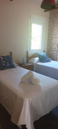 a room with two beds and a window at La Casona del Asno in Alcalá de Henares