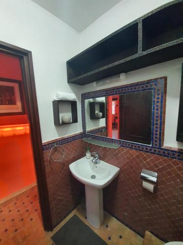 ein Bad mit einem Waschbecken und einem Spiegel in der Unterkunft AZAWAN HOUSE in Tamraght Ouzdar