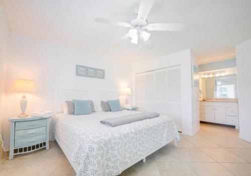 um quarto branco com uma cama e uma ventoinha de tecto em Oasis 21 Oceanfront with Pool em Saint Augustine