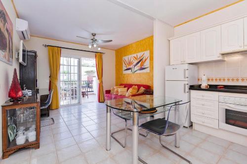 uma cozinha e sala de estar com uma mesa de vidro em Penthouse El Mirador Los Cristianos Tenerife - VV em Los Cristianos