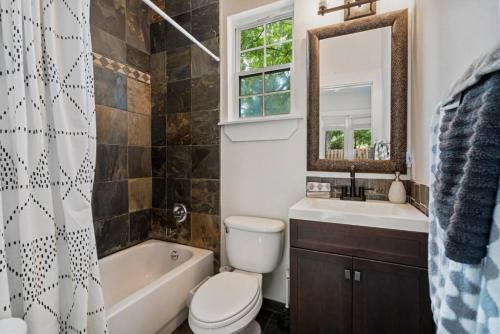a bathroom with a toilet and a tub and a sink at Whitefish Lodge in St. Augustine