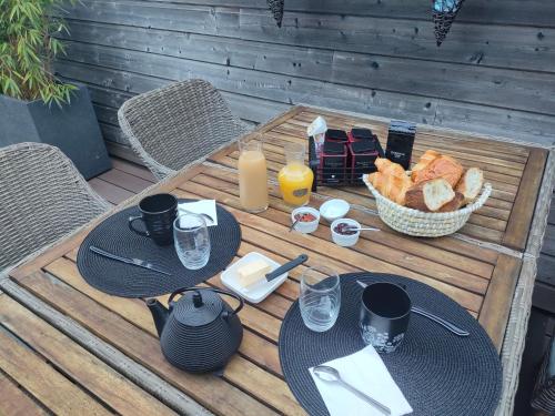 una mesa con dos platos de comida y una cesta de pan en LOFT 2 Descartes, en Le Mans
