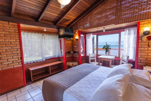 a bedroom with a bed and a view of the ocean at Pousada Mar de Dentro in Florianópolis