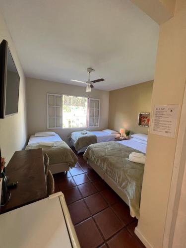 Habitación con 2 camas y TV. en Hotel Girassol da Serra, en Santa Maria Madalena