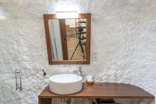 un lavandino in bagno con specchio e macchina fotografica di Casa rural el palomar del Júcar ad Alcalá del Júcar