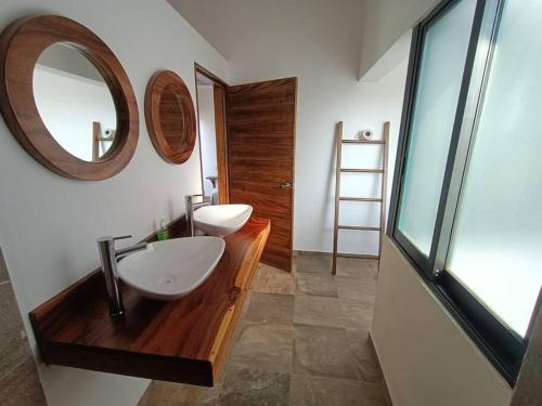 a bathroom with two sinks and a mirror on the wall at Casa Tres Iguanas, La Punta in Puerto Escondido