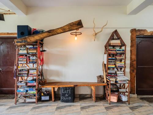a room with a wooden bench and bookshelves at The Bunker Bir in Bīr
