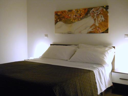 a bedroom with a bed with a painting on the wall at B&B Lucana 22 in Matera