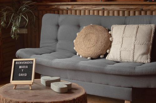 a blue couch sitting in a living room with a sign at Glamping con jacuzzi cerca a Medellin in Guarne
