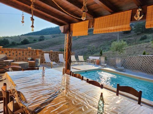 un patio con una mesa y una piscina en Casa dei Nonni, en Roccascalegna