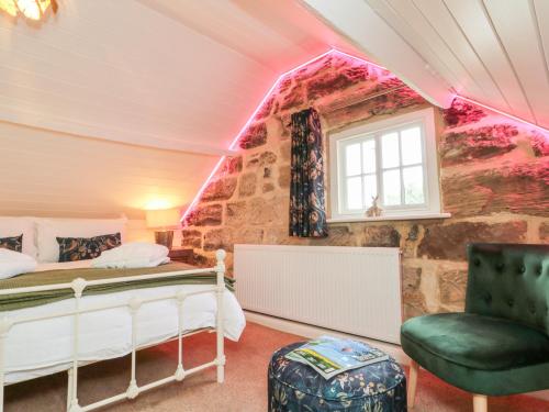 1 dormitorio con cama, ventana y silla en Red Grouse Cottage, en Guisborough