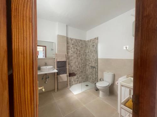 a bathroom with a toilet and a sink at Casa Barrera in Tigaday