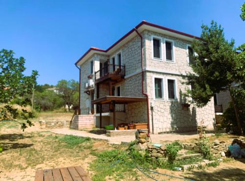 a large brick house in the middle of a yard at Paradise İmroz Butik Otel in Gokceada Town