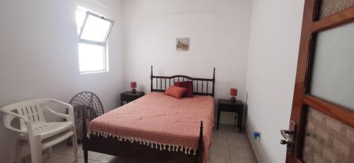 1 dormitorio con 1 cama, 1 silla y 1 ventana en Lexa Guest Apt, en Praia