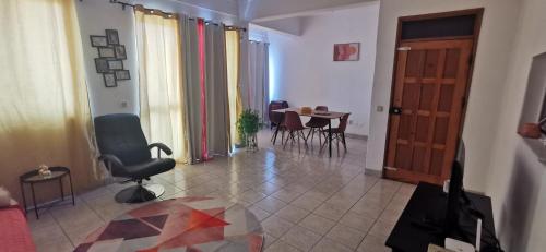 a living room with a chair and a table and a door at Lexa Guest Apt in Praia