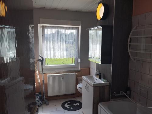 a small bathroom with a toilet and a window at Ländliche Erholung 2 in Heideland
