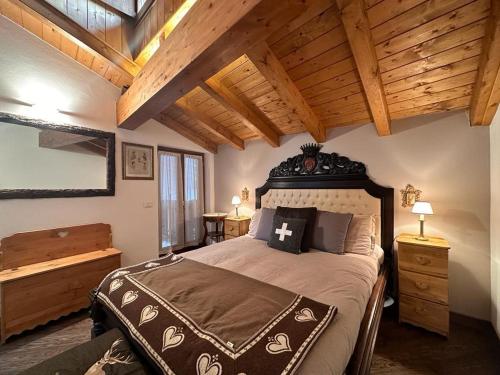 ein Schlafzimmer mit einem großen Bett und einer Holzdecke in der Unterkunft Nido Mountain Apartment in Castione della Presolana