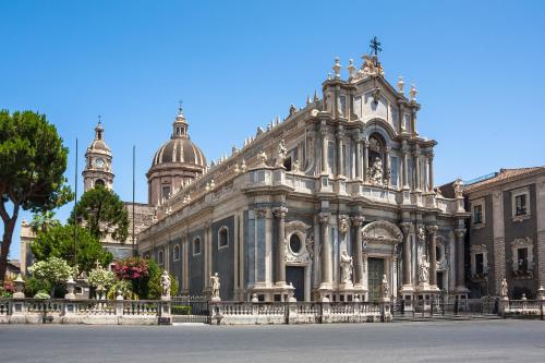 a large stone building with a cathedral in the background at VICOLO SAN GAETANO -luxury rooms- in Catania
