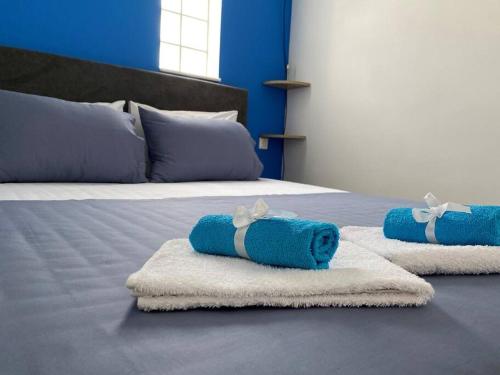 two blue towels on a bed in a room at Olympus' gods/ near Acropolis/S.A.X. in Athens