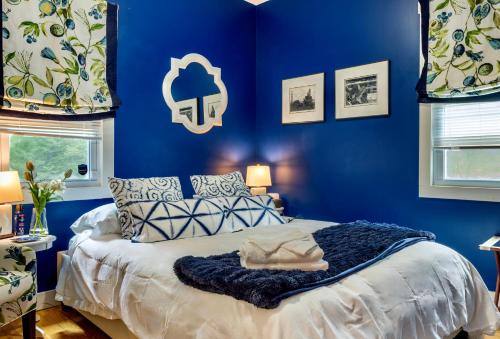 een blauwe slaapkamer met een bed met een blauwe muur bij 1890 CapeCod farmhouse:Charming, Private, Spacious in Saugerties