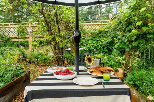 a table with plates of food and an umbrella at 1890 CapeCod farmhouse:Charming, Private, Spacious in Saugerties