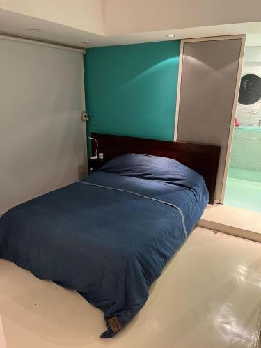 a bed in a room with a blue wall at Apart Recoleta con jacuzzi y balcón con parrilla propio in Buenos Aires