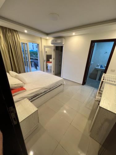 a bedroom with a large bed and a balcony at Alamein apartments prime residence in El Alamein