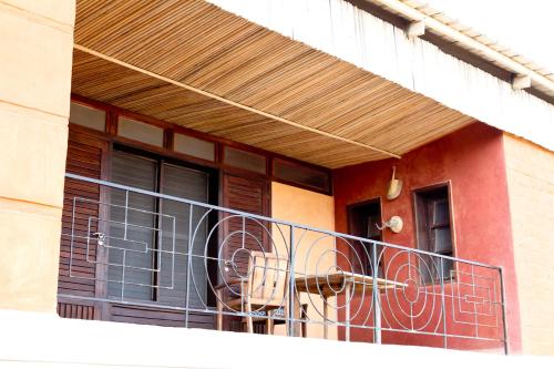 a dog sitting on a balcony of a building at La Maison Bleue Lome in Lomé