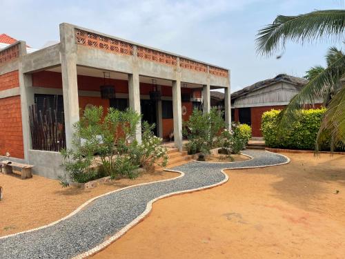 a building with a pathway in front of it at La Maison Bleue Lome in Lomé